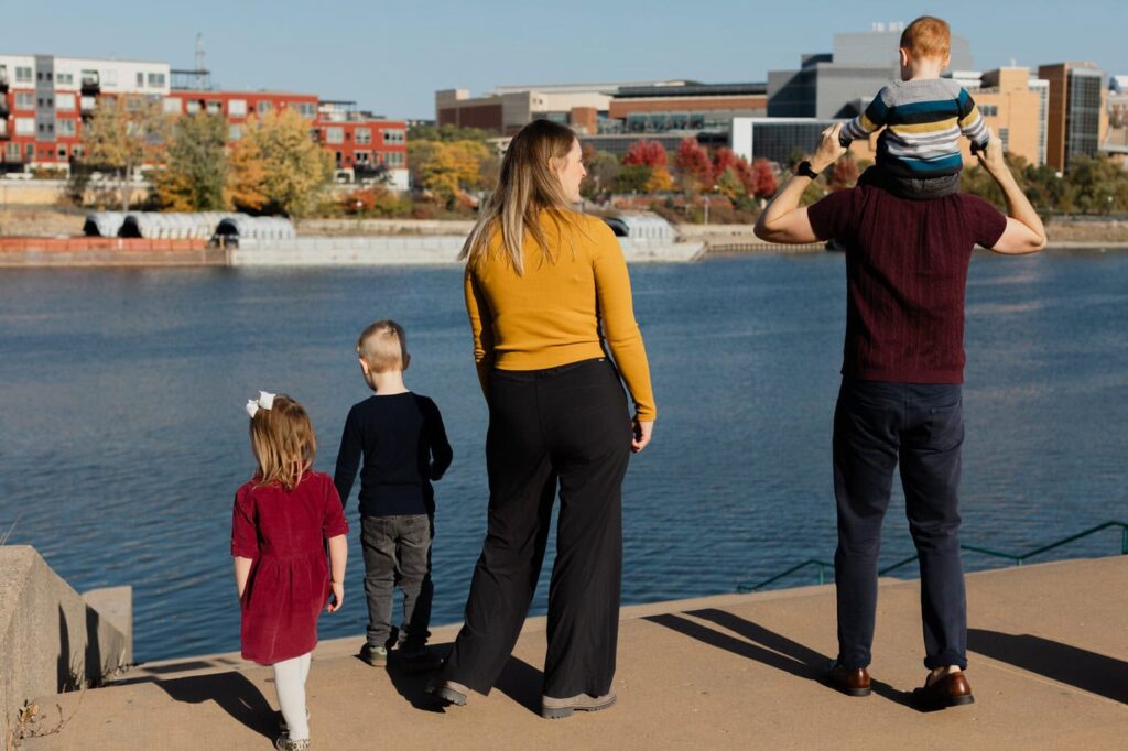 family photo of 5 people from behind with st paul skyline