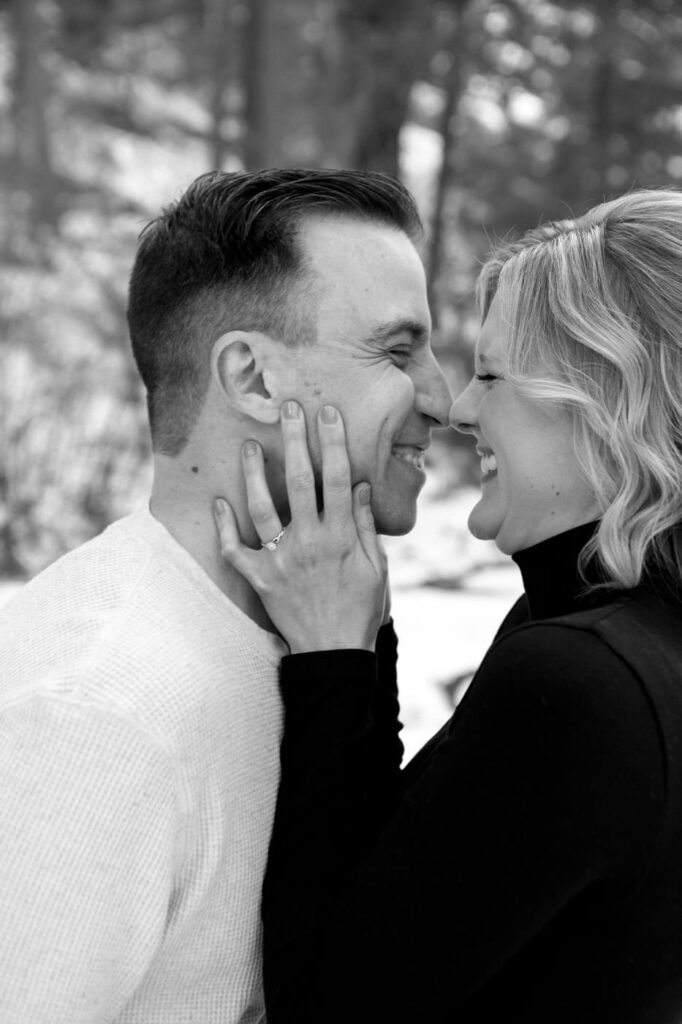 a couple touch noses and smile and her hand is on his face