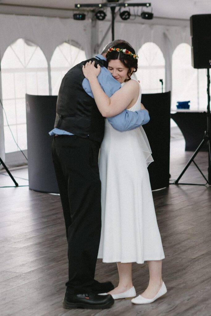 father embraces his daughter the bride on the dance floor