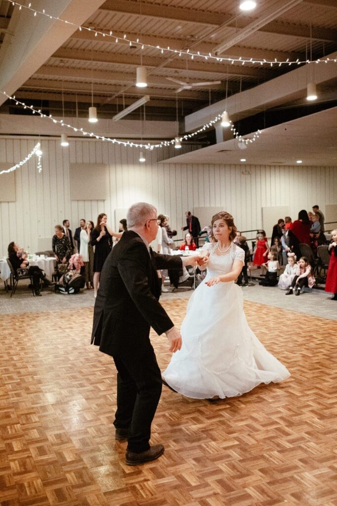 father and daughter swing dance at wedding reception