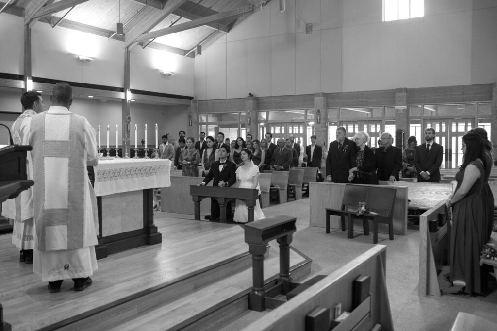 bride and groom kneel at front of church before the eucharist