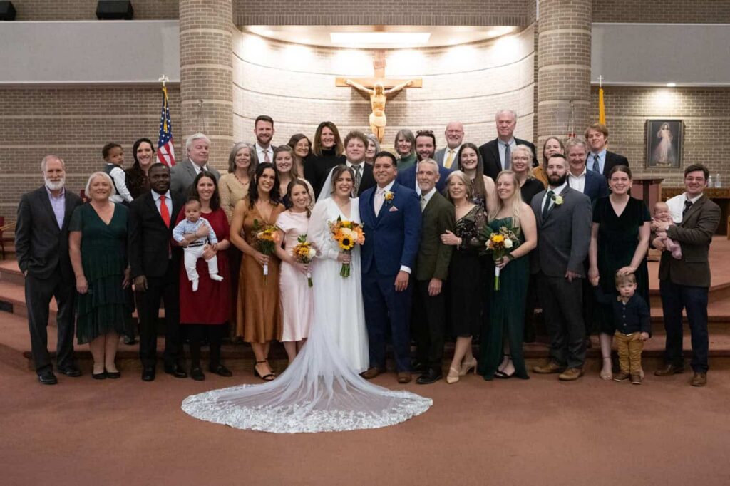 Extended family portrait in front of catholic church after wedding mass