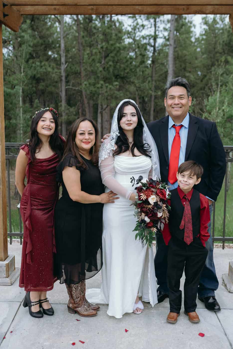 Bride with her family posing for a formal photo after the ceremony outside