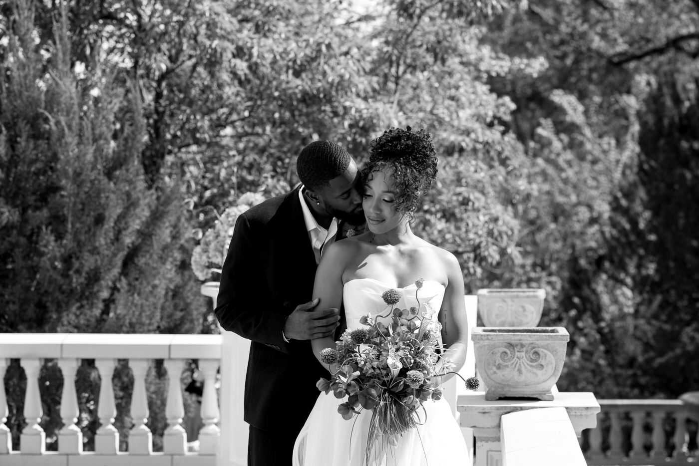 Groom nuzzles bride's cheek standing slightly behind her at Grant Humphrey's Mansion in Denver, Colorado.